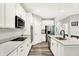 Modern kitchen featuring stainless steel appliances, a stylish island, white cabinets, and wood grain vinyl plank flooring at 16693 Churning Way, Noblesville, IN 46060