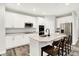 Bright kitchen with an island bar, stainless steel appliances, sleek quartz countertops, and a wooden floor at 16693 Churning Way, Noblesville, IN 46060