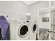 Bright laundry room features modern washer, dryer, wire shelving, and wood-look floors at 16693 Churning Way, Noblesville, IN 46060