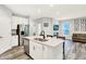 Stylish open-concept kitchen and living room area featuring stainless steel appliances, a kitchen island, and comfortable seating at 16693 Churning Way, Noblesville, IN 46060
