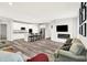 Spacious living room showcasing an open-concept design, a kitchen, hardwood floors, a sofa, and comfortable seating at 16693 Churning Way, Noblesville, IN 46060