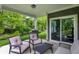 Covered patio with seating and a grill surrounded by green foliage at 16693 Churning Way, Noblesville, IN 46060