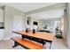 View of the open-concept dining area featuring a rustic wooden table and bench seating at 1713 Hemlock Cir, Greenfield, IN 46140