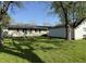 View of a grassy backyard with a detached garage and mature trees, offering a serene outdoor space at 1716 Arlene Dr, Indianapolis, IN 46219