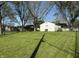 Spacious backyard featuring a detached garage, mature trees, and a lush lawn, creating a serene outdoor space at 1716 Arlene Dr, Indianapolis, IN 46219