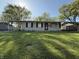 Inviting single-story home with a covered parking area and a lush green lawn, offering a welcoming facade at 1716 Arlene Dr, Indianapolis, IN 46219