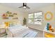 Bright bedroom features a ceiling fan, a large window and colorful decor at 181 Tracy Ridge Blvd, Whiteland, IN 46184