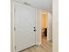 Hallway with a view of a bright half-bathroom with wood-look flooring and a white door at 181 Tracy Ridge Blvd, Whiteland, IN 46184