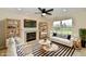 Bright living room featuring a fireplace, ceiling fan, and large windows offering views of the outdoors at 181 Tracy Ridge Blvd, Whiteland, IN 46184