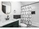 Modern bathroom with a dark vanity, black fixtures, and a shower tub combo at 1852 Singleton St, Indianapolis, IN 46203