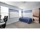 Comfortable bedroom with carpet flooring, horizontal blue stripe accents, and an attached workstation at 1852 Singleton St, Indianapolis, IN 46203