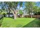 Wide backyard space with mature trees, green lawn, and a wooden fence, perfect for outdoor activities at 2307 Magnolia Pl, Indianapolis, IN 46219