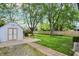 View of the backyard featuring a storage shed, large lawn and brick paver path at 2307 Magnolia Pl, Indianapolis, IN 46219