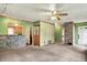 Open concept living room with hardwood trim, carpet, and a view of the kitchen featuring a bar window at 2307 Magnolia Pl, Indianapolis, IN 46219