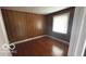 Cozy bedroom showcasing a wood paneled wall, hardwood floors, and a window at 2414 S Rybolt Ave, Indianapolis, IN 46241