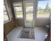 Enclosed front porch features tile flooring, a patterned rug, and lots of natural light at 2414 S Rybolt Ave, Indianapolis, IN 46241