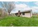 A well-maintained backyard featuring a brick chimney, patio, lush green grass, and mature trees, perfect for outdoor enjoyment at 3003 Foxpointe Dr, Columbus, IN 47203