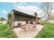 Backyard with patio featuring table, chairs, screened porch, chimney and manicured lawn at 3003 Foxpointe Dr, Columbus, IN 47203