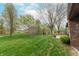 A spacious backyard featuring a chain-link fence, mature trees, and well-manicured lawn, ideal for outdoor activities at 3003 Foxpointe Dr, Columbus, IN 47203