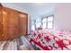 Bedroom with a red and white star patterned quilt, closet, full length mirror, and wood floors at 3003 Foxpointe Dr, Columbus, IN 47203