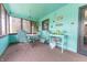 Cozy sunroom features bright turquoise decor, comfortable seating, and lots of natural light at 3003 Foxpointe Dr, Columbus, IN 47203