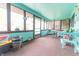 Charming sunroom with lots of windows, wood trim, turquoise walls, and neutral carpet flooring at 3003 Foxpointe Dr, Columbus, IN 47203