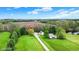 Expansive aerial shot of land featuring a long driveway, mature trees and country fields in the background at 3154 E German E Rd, Shelbyville, IN 46176