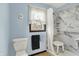 Well-lit bathroom with light blue walls, a marble shower stall, and a towel rack under a window at 3154 E German E Rd, Shelbyville, IN 46176