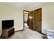 Neutral toned bedroom showing a television and glimpses of another room, enhanced by a carpeted floor at 3154 E German E Rd, Shelbyville, IN 46176