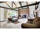 Inviting living room with vaulted ceilings, exposed beams, large windows, and a cozy brick fireplace at 3154 E German E Rd, Shelbyville, IN 46176