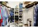 Walk-in closet features wooden shelves with folded clothes, storage boxes, hanging shirts, and personal items at 3154 E German E Rd, Shelbyville, IN 46176