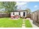 This backyard features stone pavers, a small deck, a fenced-in yard, and mature trees at 319 S Randolph St, Indianapolis, IN 46201