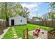 This backyard features a detached garage, green grass, a gravel seating area, and stone pavers at 319 S Randolph St, Indianapolis, IN 46201