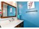 This bathroom has a large mirror over the sink and blue walls with decorative animal art at 319 S Randolph St, Indianapolis, IN 46201