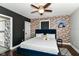 Charming bedroom with exposed brick accent wall, ceiling fan and ensuite bath at 319 S Randolph St, Indianapolis, IN 46201