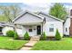Charming home featuring a covered porch, tidy landscaping and freshly painted exterior at 319 S Randolph St, Indianapolis, IN 46201
