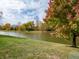 Scenic pond view with lush green surroundings and vibrant autumn foliage under a partly cloudy sky at 3286 W Longbranch Dr, Monrovia, IN 46157
