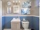 Cozy bathroom featuring a vanity, toilet, and stylish blue wainscoting at 3405 W 8Th Street Rd, Anderson, IN 46011