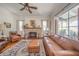 Cozy living room with a brick fireplace, leather furniture, decorative rug, and abundant natural light at 3405 W 8Th Street Rd, Anderson, IN 46011