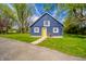 Charming blue outbuilding with a yellow door, surrounded by lush greenery at 3405 W 8Th Street Rd, Anderson, IN 46011