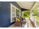 Cozy front porch with wicker furniture, decorative pillows, and view of the manicured yard at 3405 W 8Th Street Rd, Anderson, IN 46011