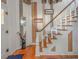 Elegant staircase with wood treads, a white banister, and decorative wall art at 3405 W 8Th Street Rd, Anderson, IN 46011