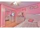 A stylish pink bedroom with mirrored closet doors, a ceiling fan, and bright natural light at 3535 Ivory Way, Indianapolis, IN 46227