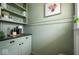 Butler's pantry with built-in shelves, custom cabinets, and complementary green paint and decor at 3864 Esquire Ct, Indianapolis, IN 46226