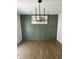Dining room featuring wainscoting, olive green paint, and a modern chandelier at 3864 Esquire Ct, Indianapolis, IN 46226