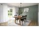 Bright dining room with wood table, modern lighting, light colored wood floors, and a backyard view at 3864 Esquire Ct, Indianapolis, IN 46226