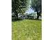 A view of the home from a distance showing the yard and mature trees at 3864 Esquire Ct, Indianapolis, IN 46226