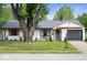 Charming single-story home featuring a tidy front lawn, blue door, and gray garage at 3864 Esquire Ct, Indianapolis, IN 46226