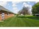 Brick home showcasing a beautiful manicured lawn, complemented by mature trees at 389 Vinewood N Dr, Brownsburg, IN 46112