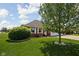 Well-manicured lawn with mature tree and green bush, leading to a brick home with an attached garage at 389 Vinewood N Dr, Brownsburg, IN 46112